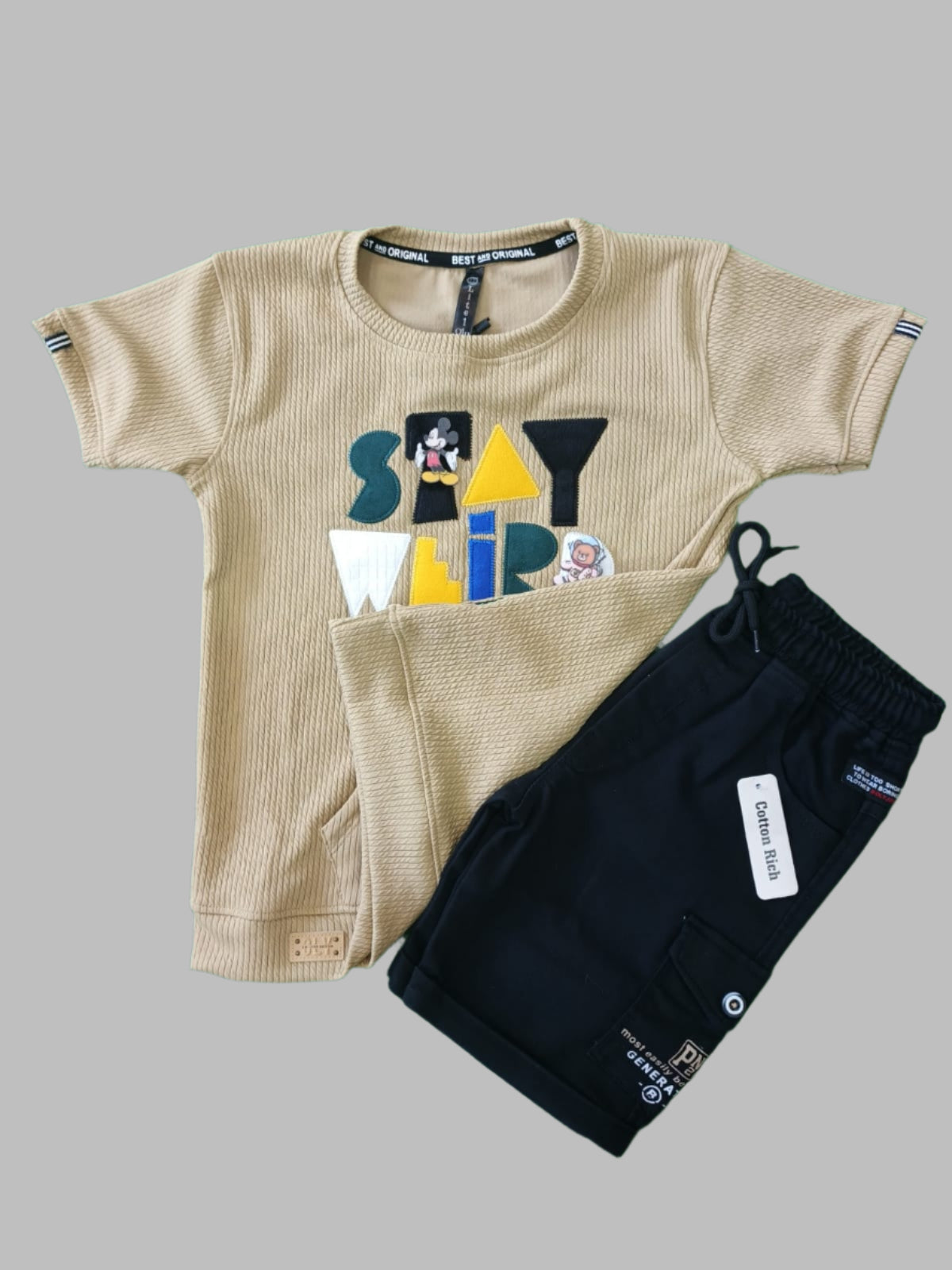 Beige and black children's outfit on a green background