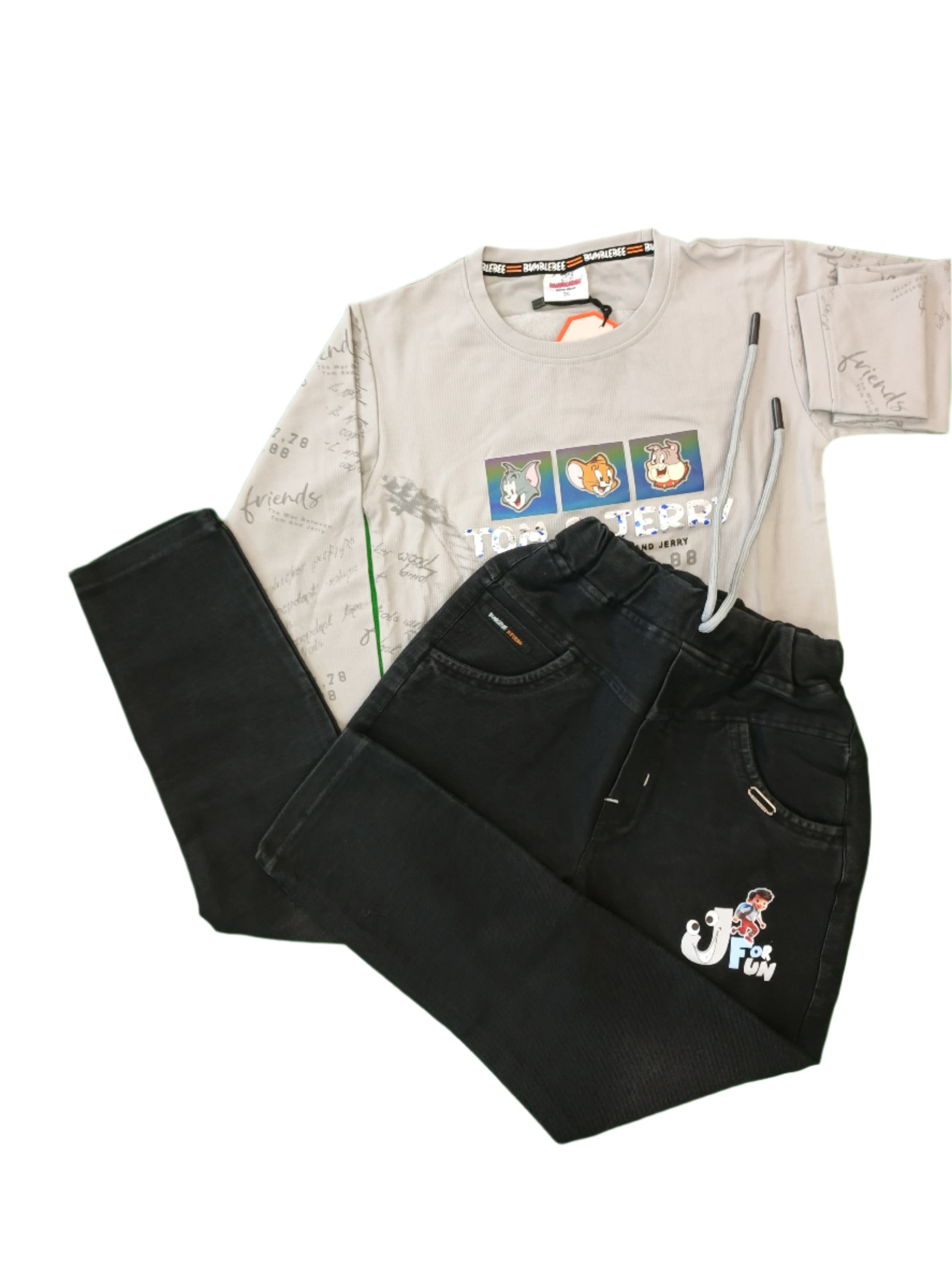 Black pants and a white shirt with graphics on a green surface