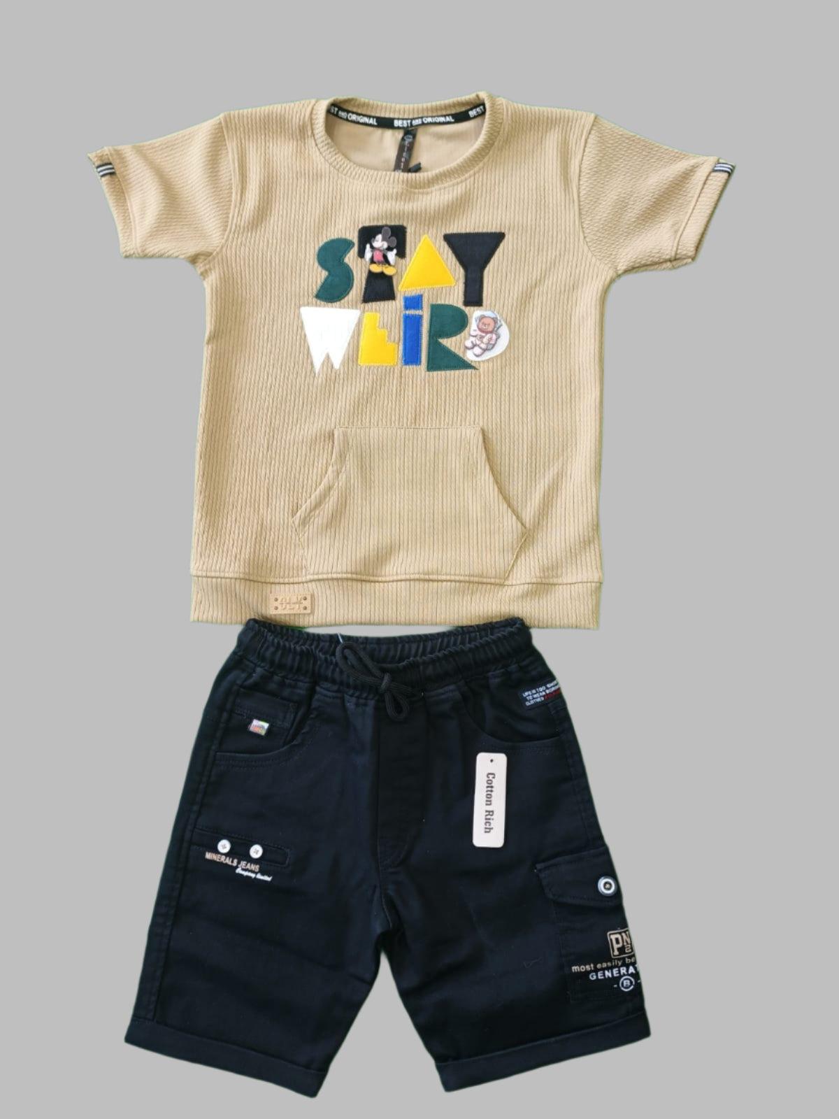 Black shorts and beige sports jersey with colorful design on a green background
