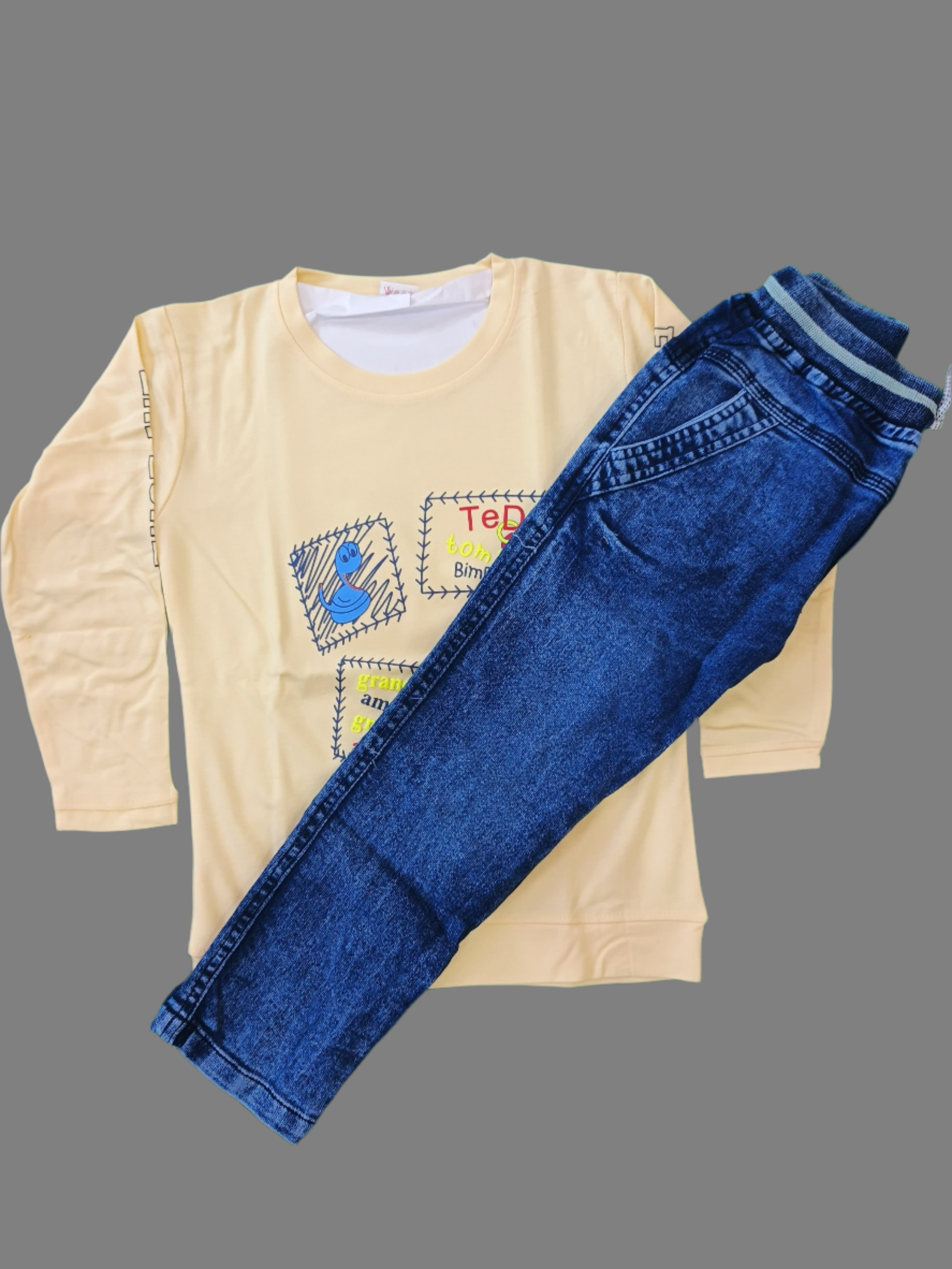 Blue jeans and a yellow shirt with colorful designs on a green background