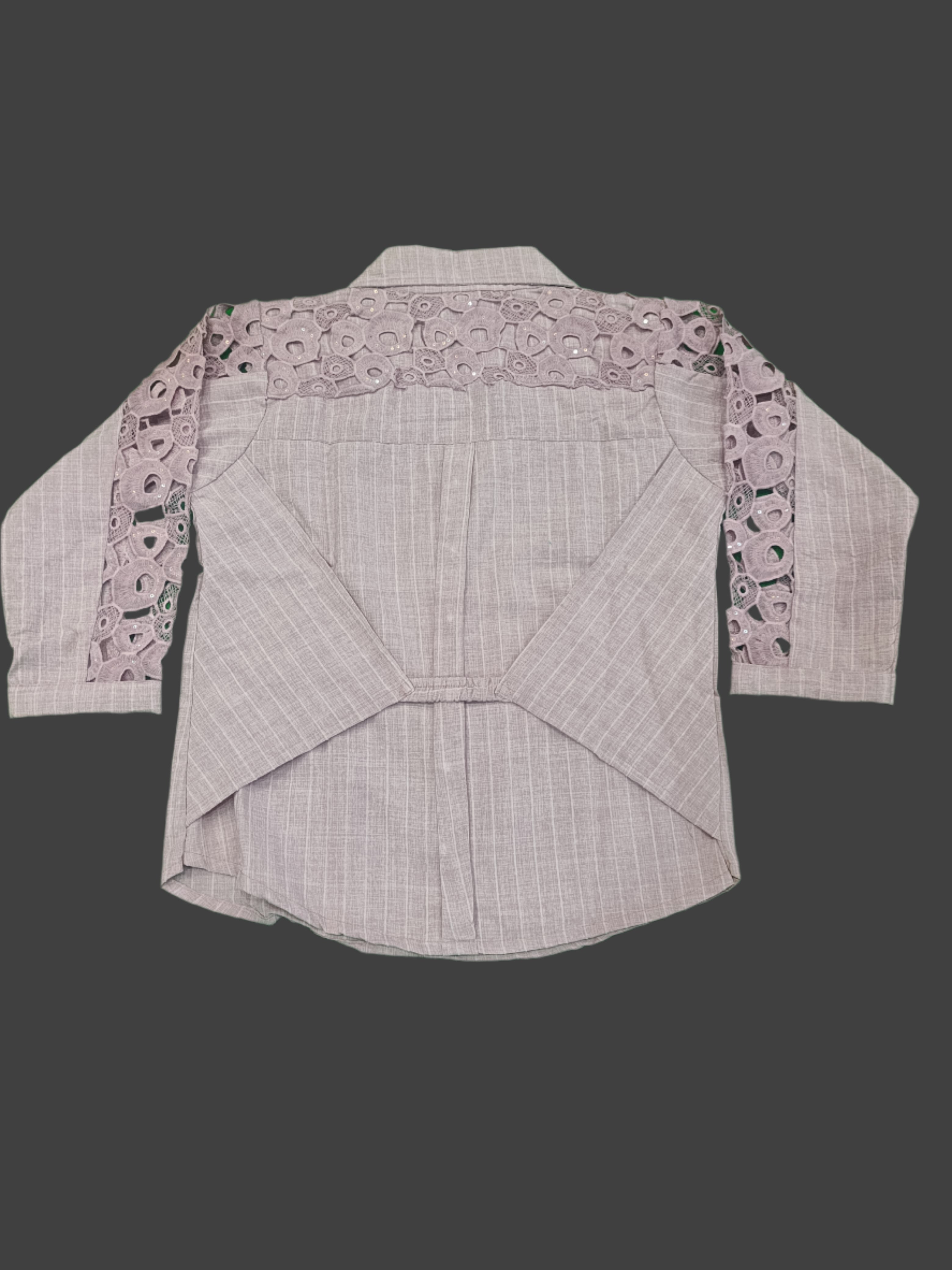 Light pink blouse with lace details on a green surface