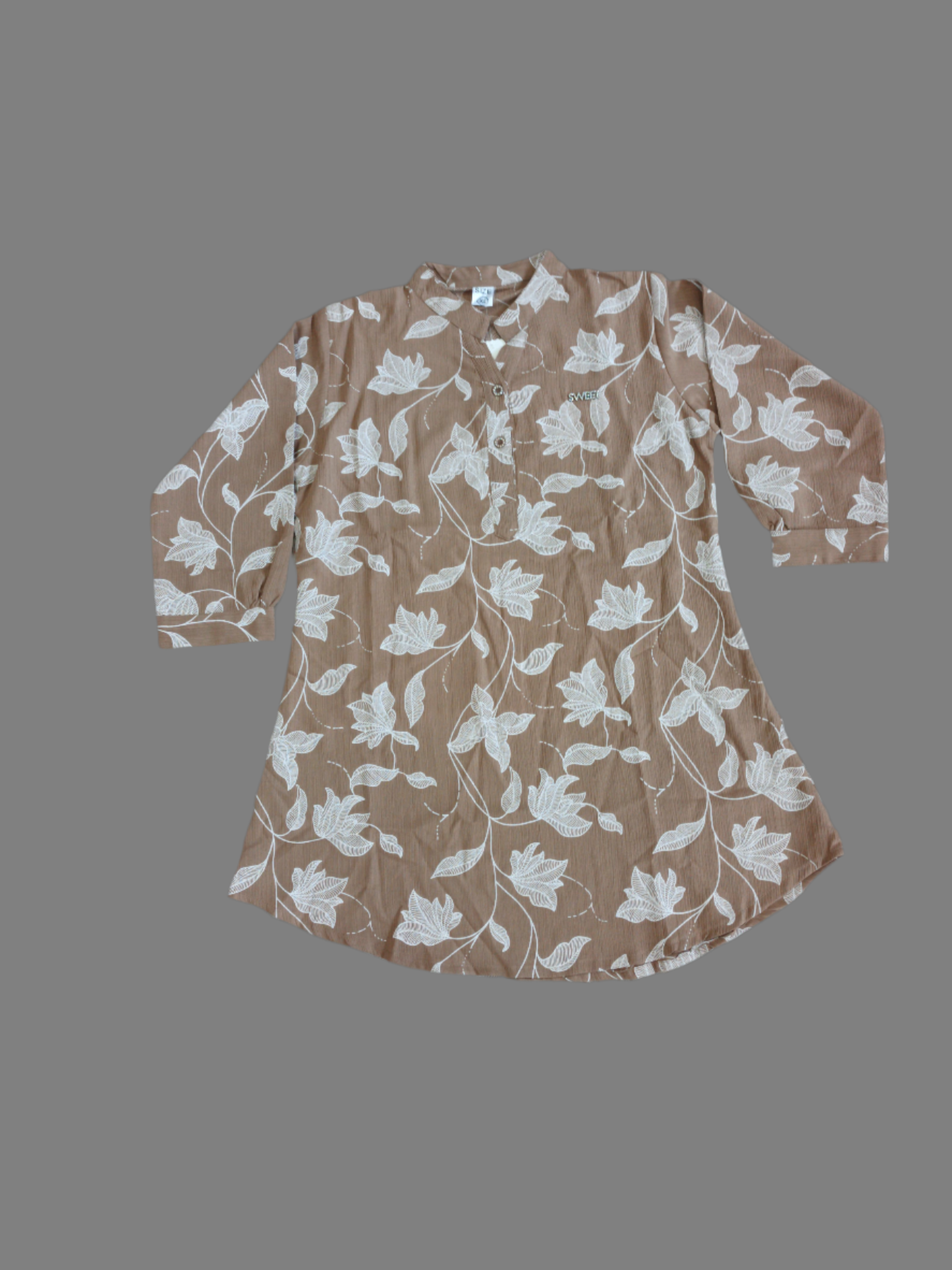 Woman wearing a light blue floral print shirt against a black background