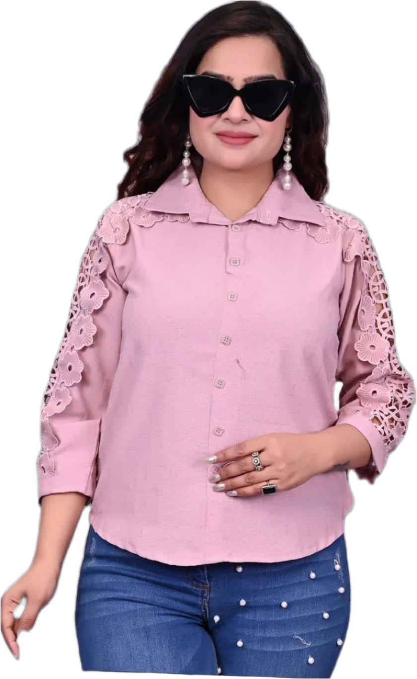 Woman wearing a pink blouse with floral sleeves on a black background