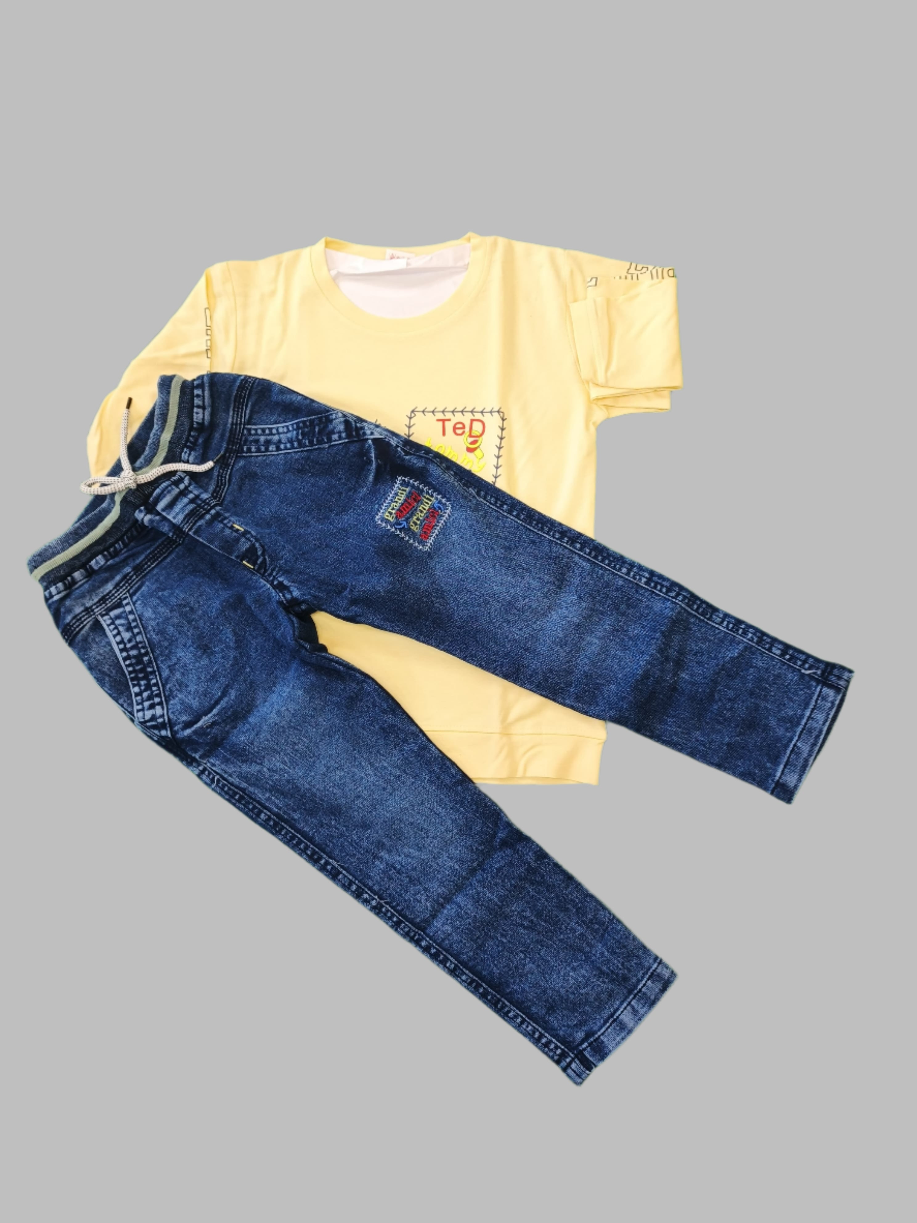 Yellow t-shirt and blue jeans on a green background